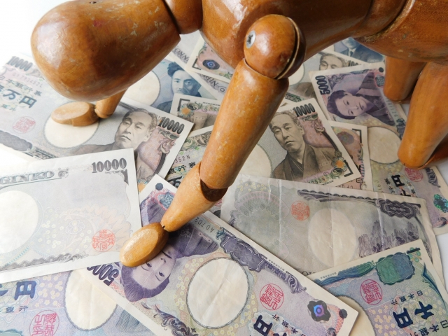 お金の上でうなだれる。四国中央市で借金返済の相談は無料でできます